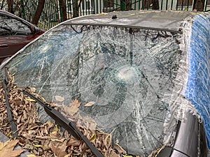 Broken car windshield of a damaged and crushed automobile, clear glass repair
