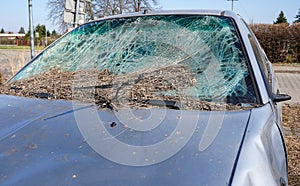 Broken car windshield. Old and abandoned car on the parking. Smashed window.