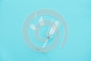 Broken champagne glass with splinters on blue background with copy space. Concept fight against alcoholism, drunkenness and