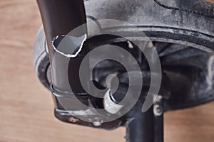 Broken chassis of a baby stroller, damage to the crossbar of the metal frame of the pram