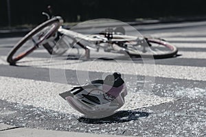 Broken child`s helmet and bike on pedestrian crossing after accident