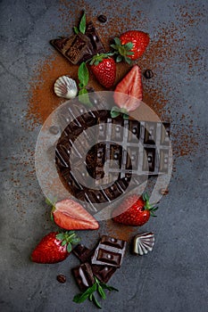 Broken chocolate blocks with strawberries