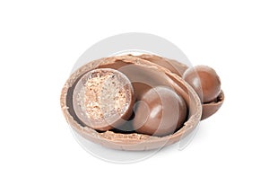 Broken chocolate Easter egg with candies on white background