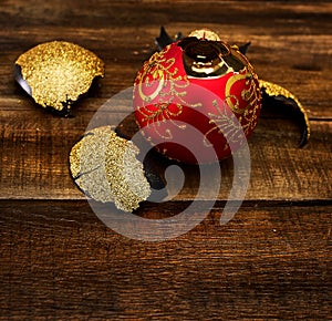 Broken Christmas ball with glass shards on wooden table