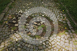 Broken cobbles with grass in the city park