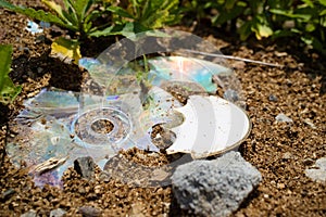 Broken compact disk, obsolete technology in the trash