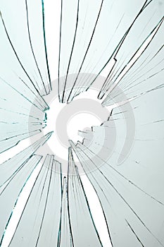 Broken and cracked glass with hole on a white background