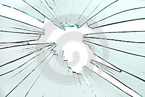 Broken and cracked glass with hole on a white background