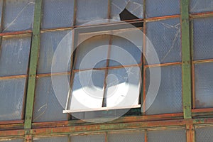 Broken and cracked industrial windows in metal frames photo