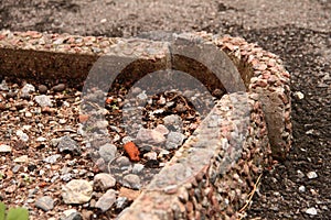 A broken curbstone with asphalt and stones
