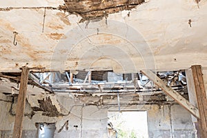 Broken damaged and collapsed ceiling and roof of old house abandoned after aftermath disaster and heavy rain leakage