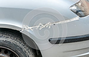 Broken and damaged front bumper on the silver car