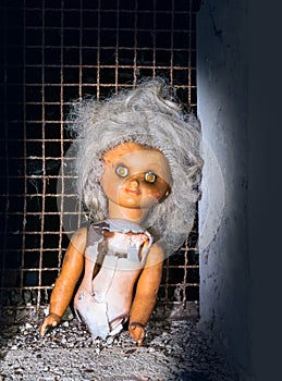 Broken deserted doll lit by mystery light