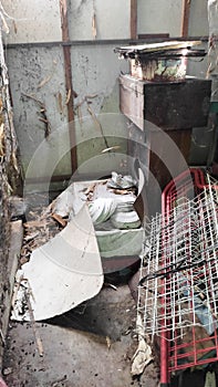 a broken dish rack in a dirty, unkempt warehouse