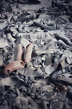 A broken doll's legs on a pile of soviet gas masks in an abandoned building in Pripyat, Ukraine, Chernobyl exclusion zone.