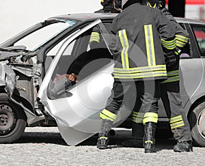 Broken door of car after accident and firemen