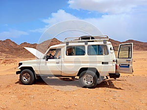 Broken down jeep with the hood open in the desert of the Sinai Peninsula. Red Sea coast and adventure routes through the Dahab