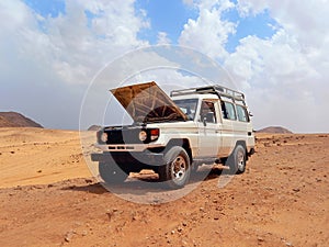 Broken down jeep with the hood open in the desert of the Sinai Peninsula. Red Sea coast and adventure routes through the Dahab