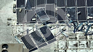 Broken down photovoltaic solar panels destroyed by hurricane Ian winds mounted on industrial building roof for producing
