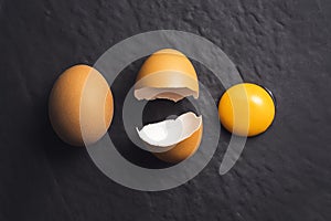 Broken egg on black textured background