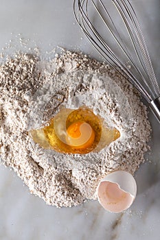 Broken egg on flour on marble background