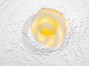 Broken egg on flour, for making bread
