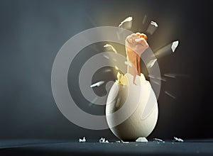 Broken egg with hand isolated on gray background