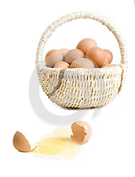 A broken egg near basket of eggs