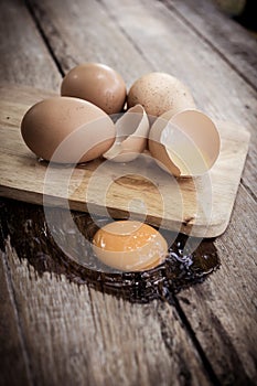 Broken egg on a wooden cutting board