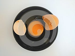 Broken eggs on white wooden table, top view.