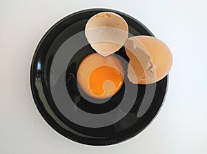 Broken eggs on white wooden table, top view.