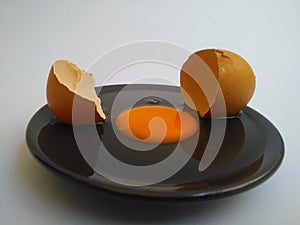 Broken eggs on white wooden table, top view.