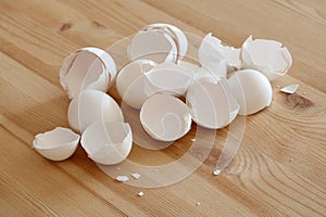 Broken eggshells lying on wooden table in kitchen