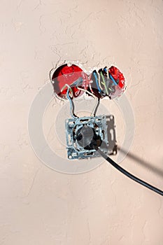 Broken electrical outlet with plug in. Danger of short circuit and fire. Improper use of devices