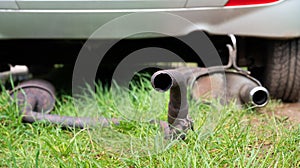 Broken exhaust and muffler of a car, rusted silencer fallen down on the road, breakdown of vehicle photo