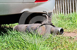 Broken exhaust and muffler of a car, rusted silencer fallen down on the road, breakdown of vehicle photo