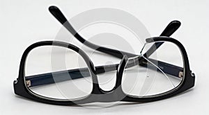Broken eyeglasses with black frame isolated on white