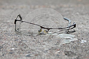 Broken eyeglasses on concrete