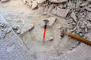 Broken floor tiles and old tiling mortar is a cracked adhesive mortar by the technicians preparing new floor tiles again in the