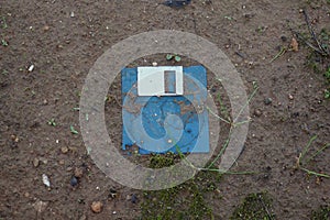 Broken floppy disk on muddy ground