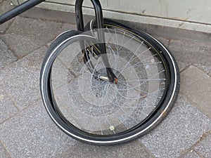 Broken frontwheel of an black bicycle in the streets of Amsterdam photo