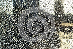 Broken glass against the background of the city, bullet holes