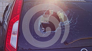 Broken glass in back door of car. Smashed rear window of auto