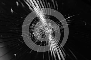 Broken glass background with bullet hole over black background