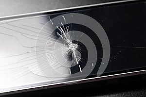 Broken glass background with bullet hole over black background.