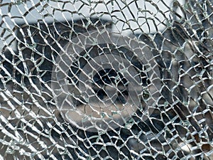 Broken glass background with a web pattern with the city in the background. Destruction, armored, vandalism