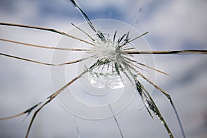 Broken Glass with Blue Sky and Clouds in Background