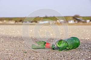 A broken glass bottle on the sand of the beach