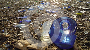 Broken glass bottles of beer and alcohol on the sidewalk. Urban pollution by glass. Environmental vandalism. Broken glass on