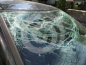 Broken glass of the broken windshield after a heavy car accident ruined the windscreen and caused an injury that shattered